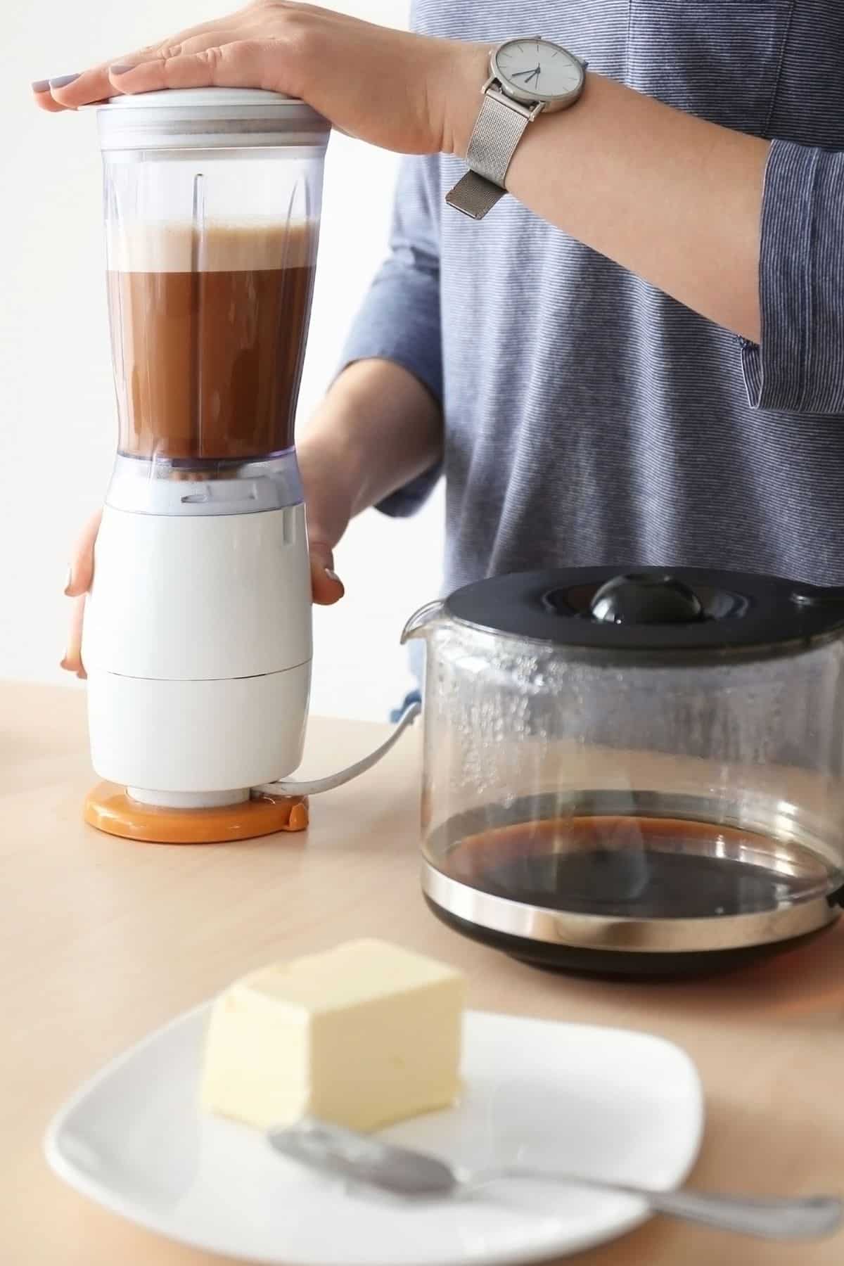 https://www.cleaneatingkitchen.com/wp-content/uploads/2020/12/woman-making-a-butter-blended-coffee.jpg