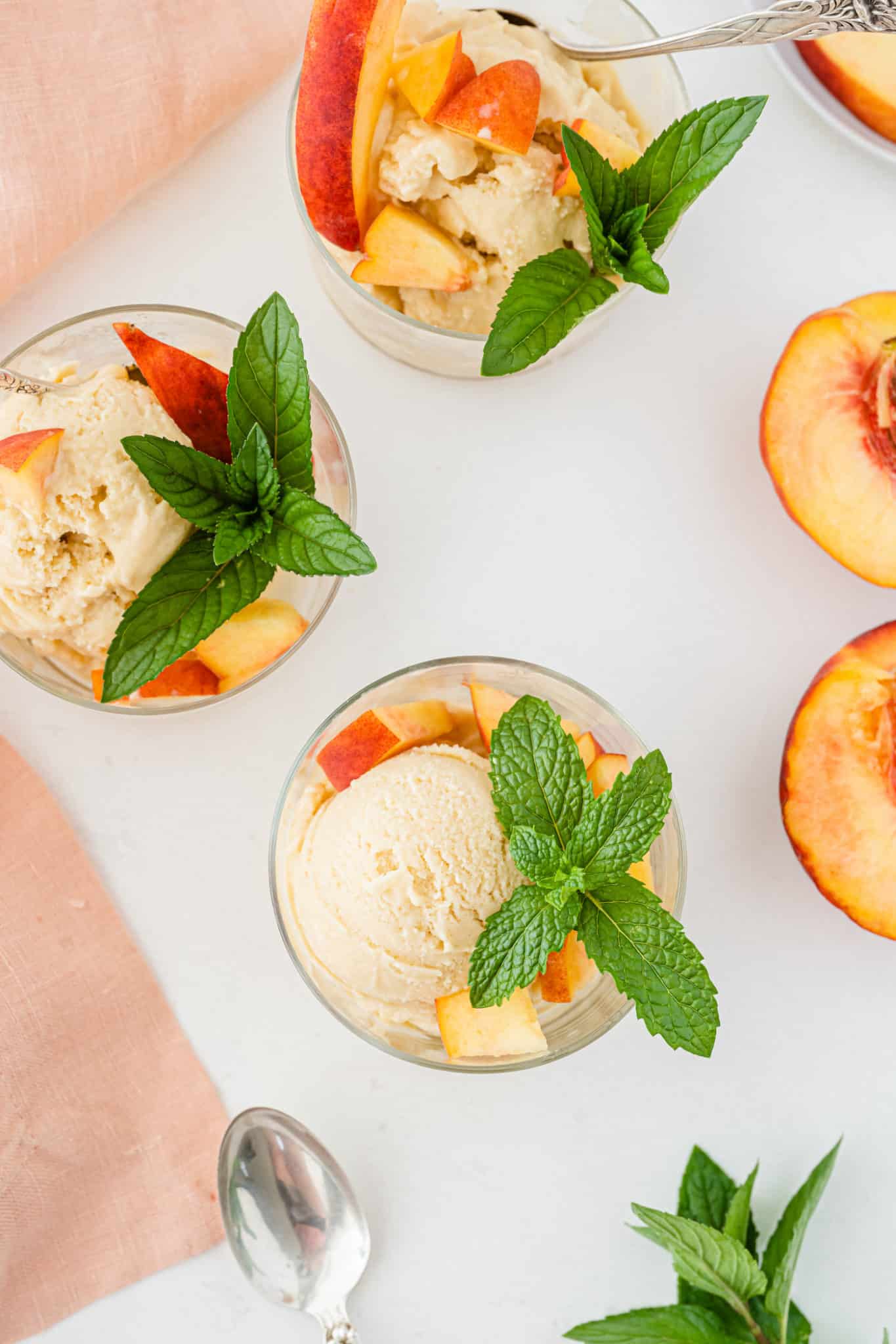 three bowls of peach ice cream on a table.