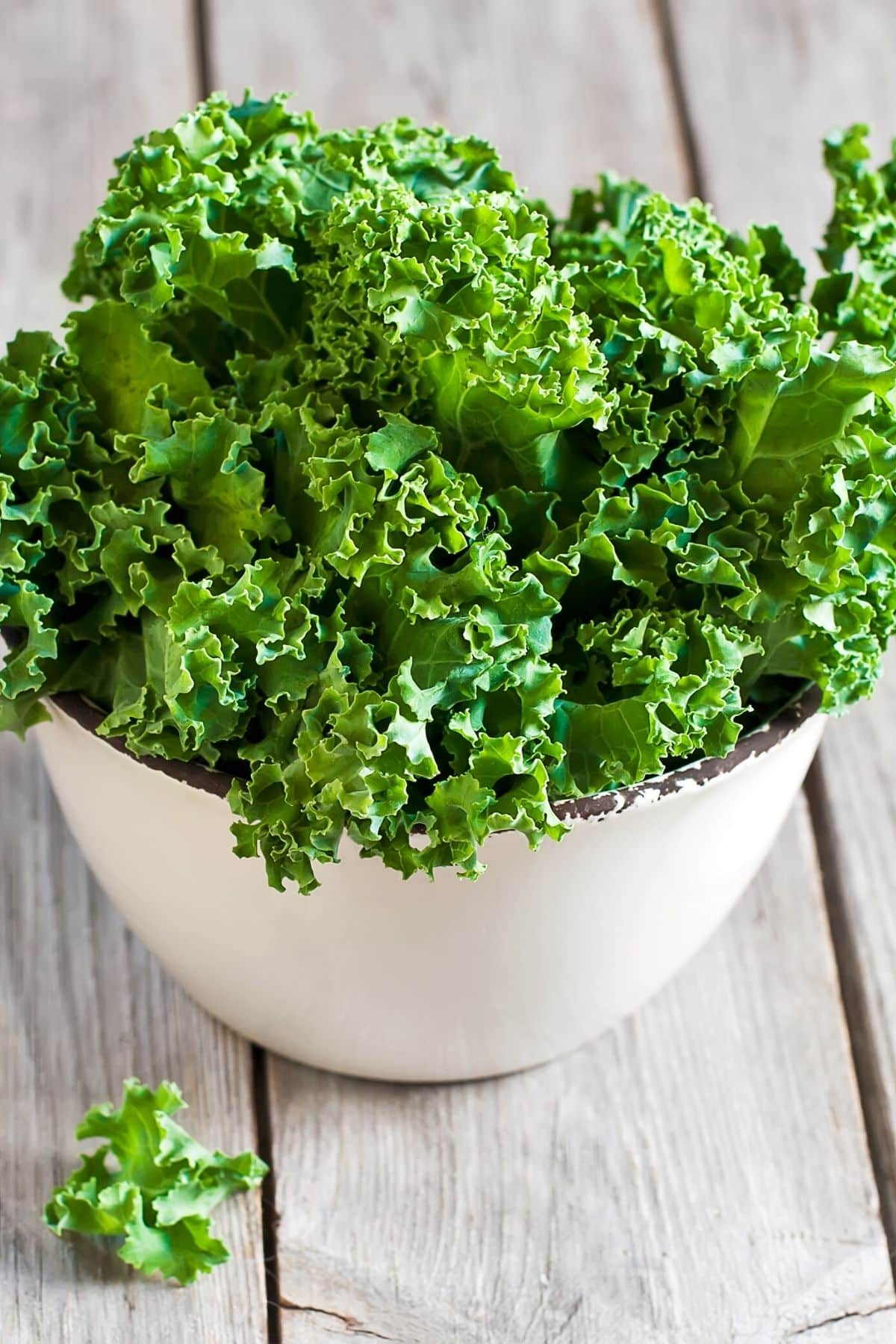 https://www.cleaneatingkitchen.com/wp-content/uploads/2022/02/kale-in-a-white-bowl-on-a-table.jpg