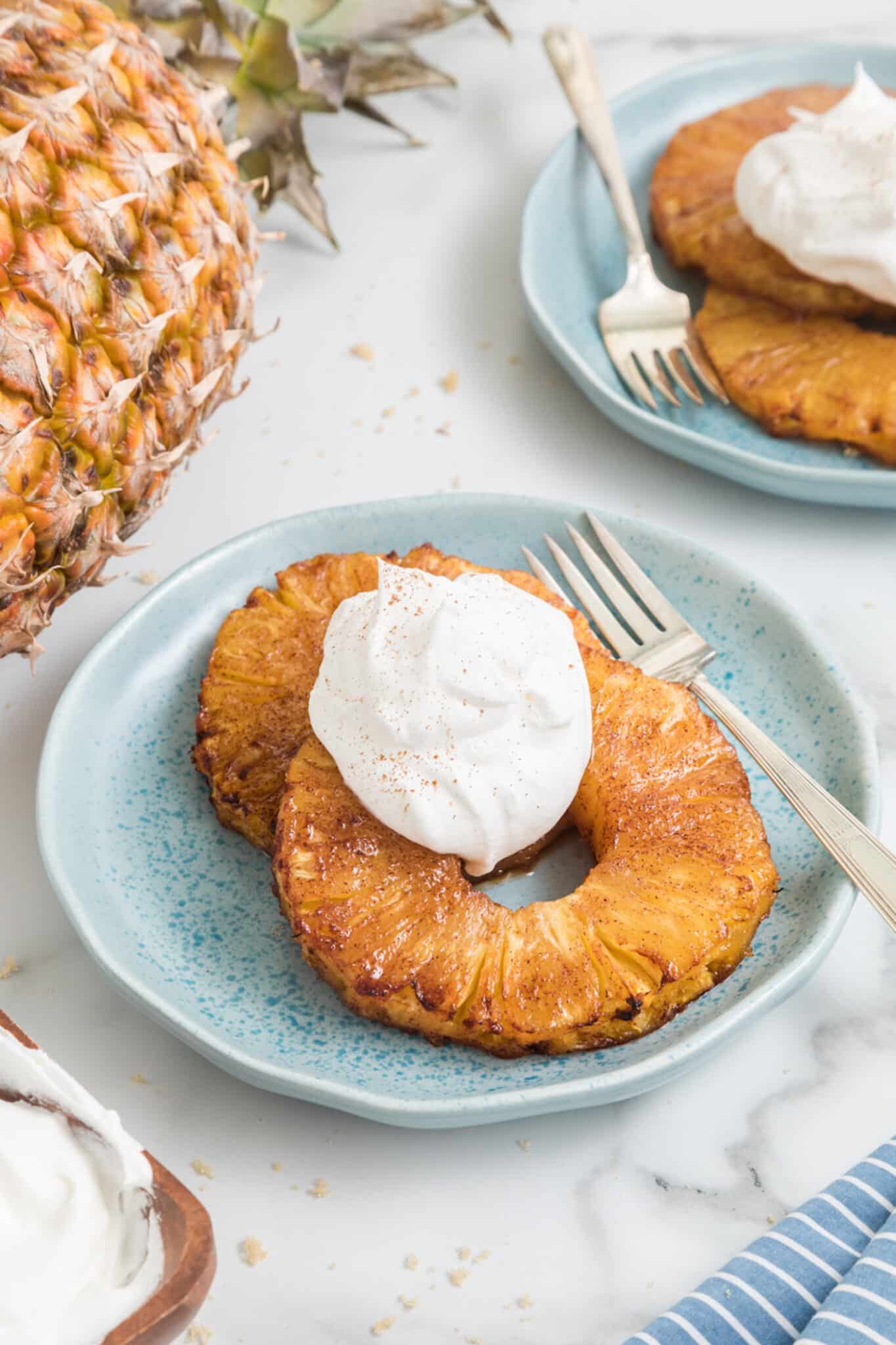 https://www.cleaneatingkitchen.com/wp-content/uploads/2022/06/air-fryer-pineapple-with-cream-hero-scaled.jpg