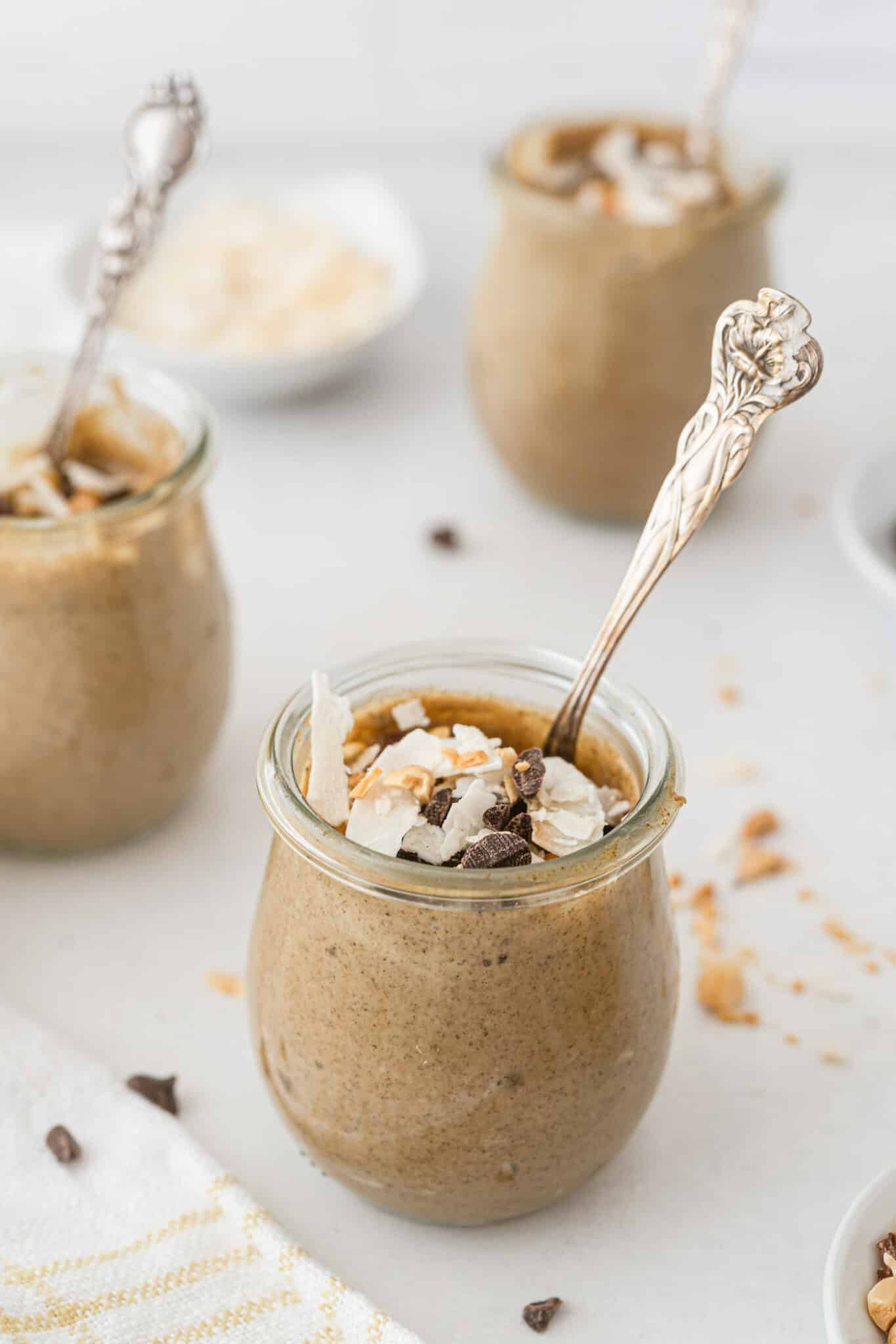 small jars of PB chia pudding topped with chocolate and coconut