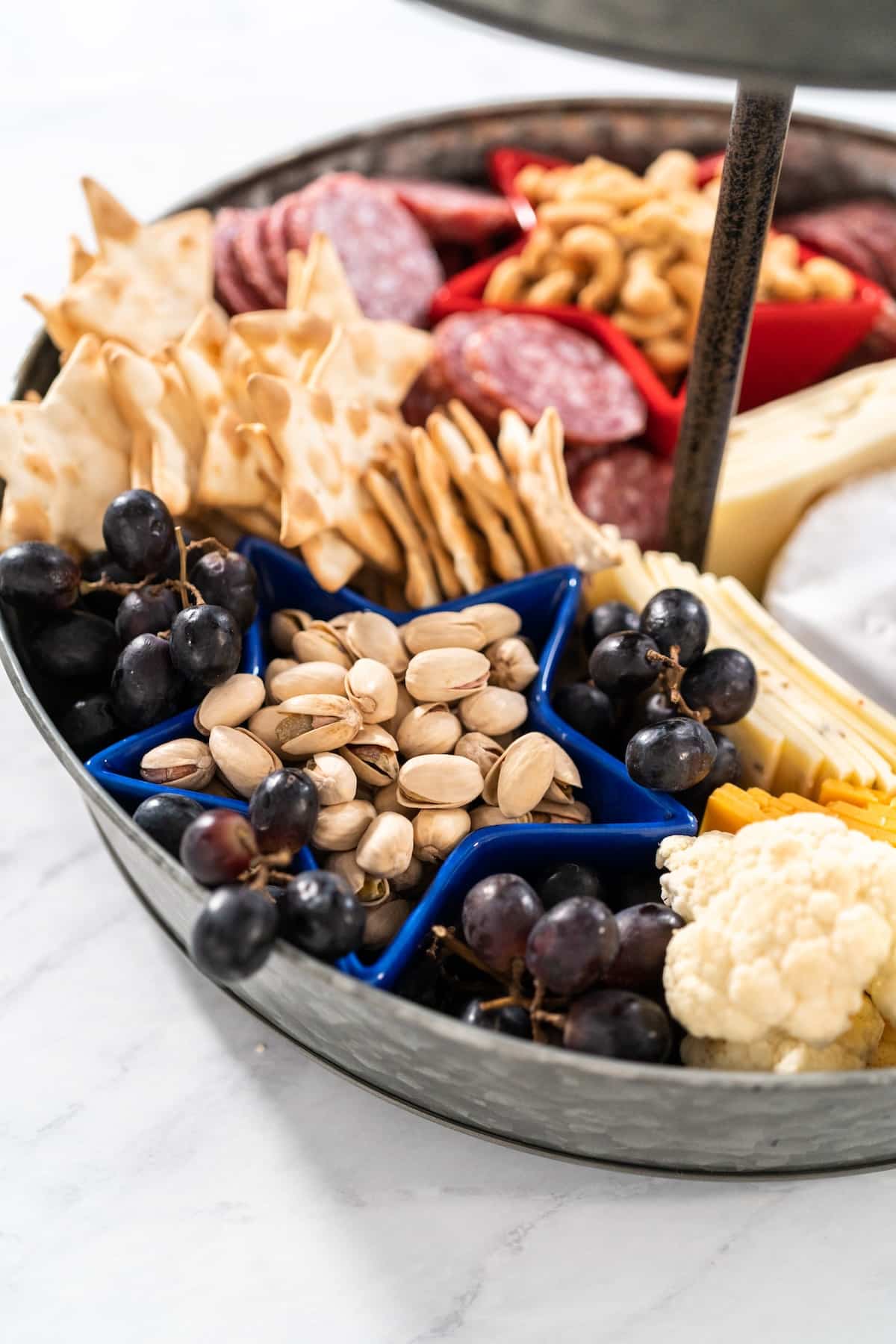 a close up of the 4th of July charcuterie board full of fruits, nuts and crackers.