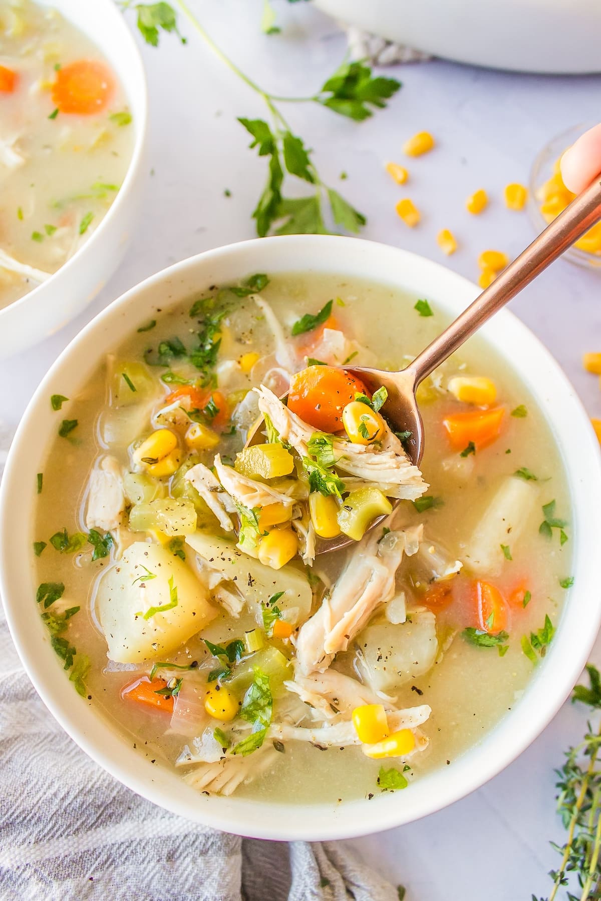 a bowl of crockpot chicken, corn and potato soup.